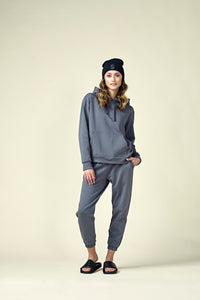 Woman in dark gray hoodie, matching joggers and a black beanie.