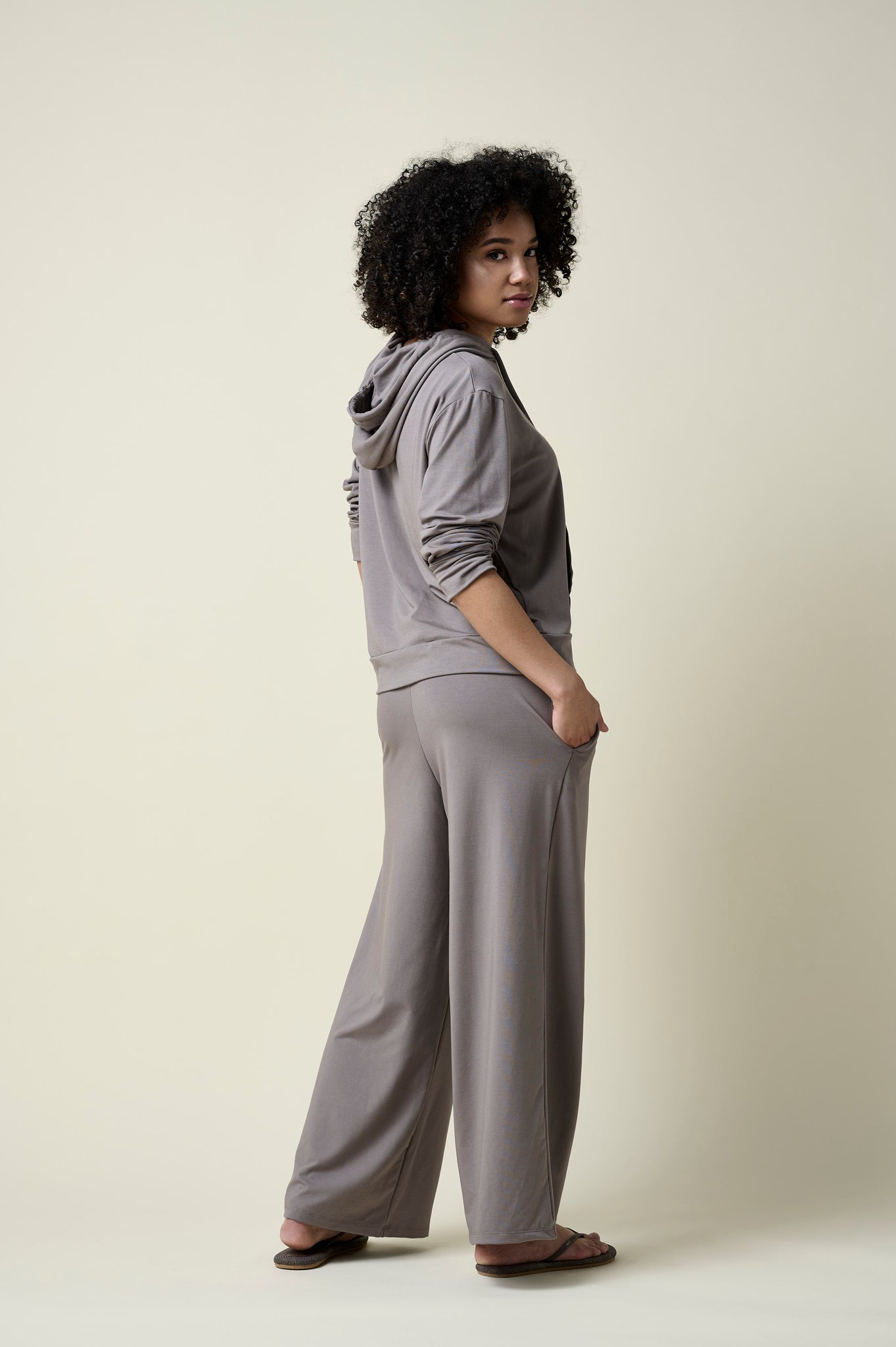 Side view of woman wearing stone coloured wide leg pants and matching hoodie.