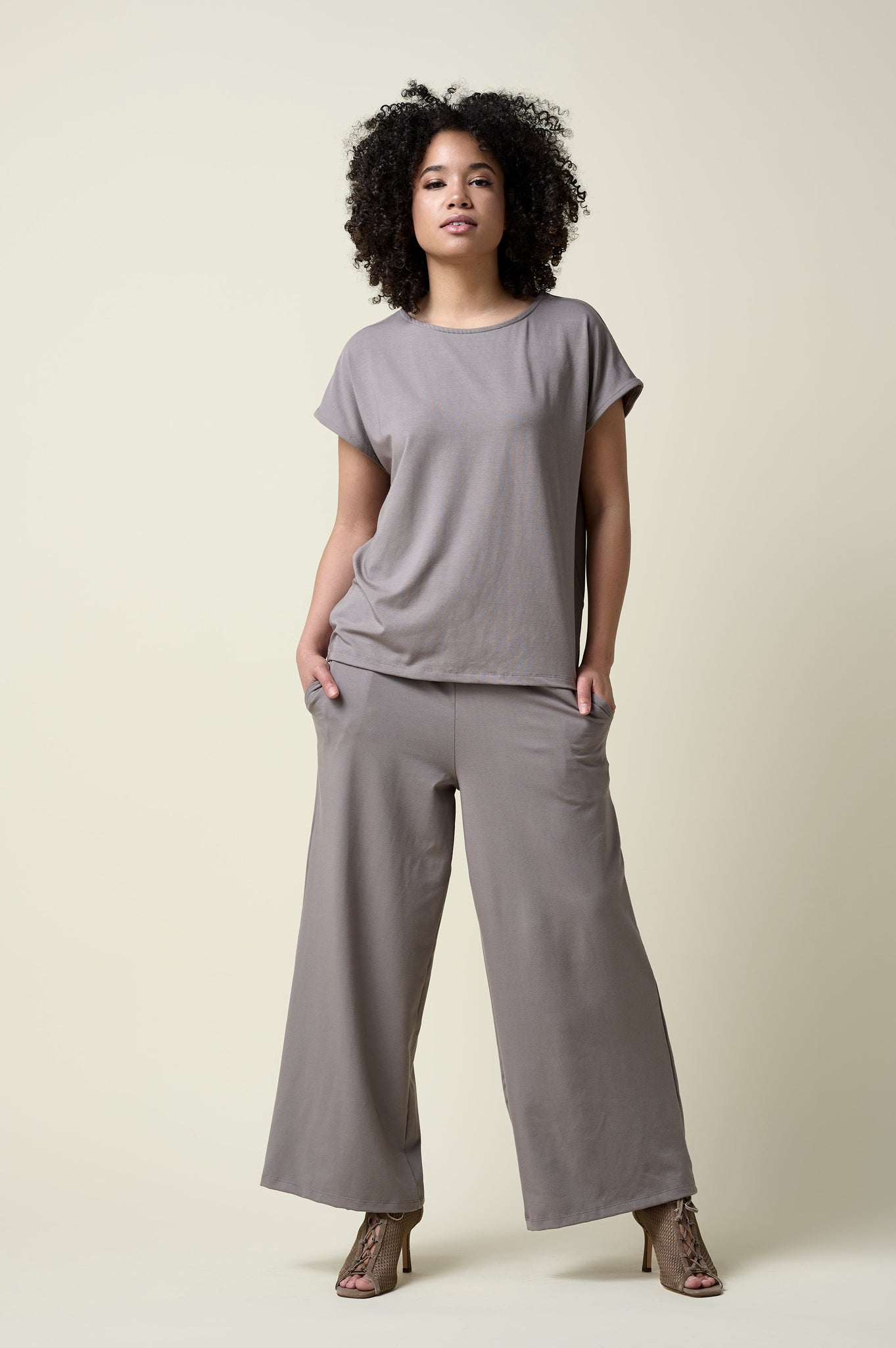 Woman wearing stone coloured wide leg pants and matching t-shirt with heels.